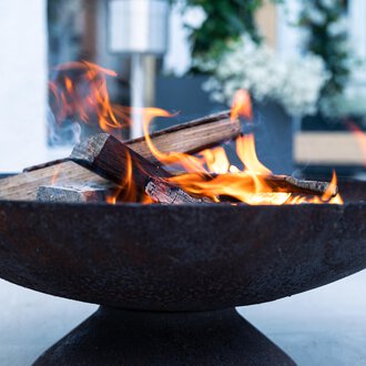 Ein rustikales Feuer in einem runden Feuerkorb. Die Flammen lodern über den Holzscheiten und schaffen eine gemütliche Atmosphäre. | © Genuss- & Aktivhotel Sonnenburg