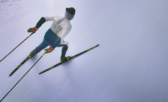 Ein Skifahrer fährt auf einer perfekt präparierten Piste. Die klare, schneebedeckte Umgebung strahlt Ruhe und Konzentration aus.