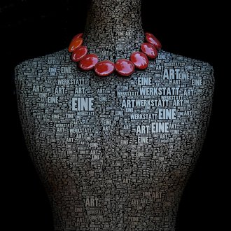 © Gerti Maitz Eine kunstvolle Darstellung eines Mannequins, das mit Worten über Kunst bedeckt ist. Es trägt eine auffällige Kette aus roten Perlen. | © Gerti Maitz