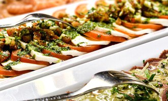 Ein Buffet mit verschiedenen Fleisch- und Fischgerichten auf weißen Platten. Darunter sind auch farbenfrohe Salate und Kräuter. | © Alpengasthof Hörnlepass GmbH