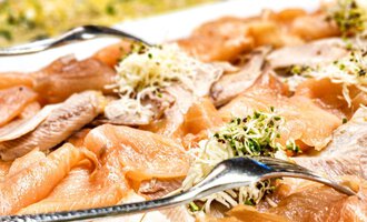 A selection of smoked fish on a white plate. The dish is decorated with fresh herbs. | © Alpengasthof Hörnlepass GmbH