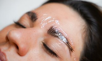 Eine Person erhält eine kosmetische Behandlung mit durchsichtiger Gelmaske auf den Augenbrauen. Sie liegt entspannt mit geschlossenen Augen da. | © Annett Schwärzler Nails & Spa | Stefanie Haid