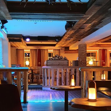 Eine gemütliche Bar mit Holzdekor und sanfter Beleuchtung. Die Sitzecken laden zum Entspannen ein. | © Hotel Steinbock