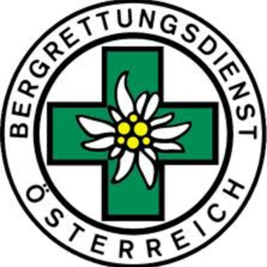 Ein Logo des Bergrettungsdienstes Österreich. Es zeigt ein grünes Kreuz mit einer Alpenblume in der Mitte.