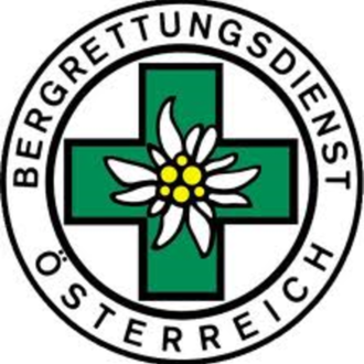 Ein Logo des Bergrettungsdienstes Österreich. Es zeigt ein grünes Kreuz mit einer Alpenblume in der Mitte.