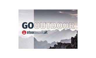 Eine beeindruckende Berglandschaft im Hintergrund mit sanften Hügeln und grauem Himmel. Im Vordergrund steht der Schriftzug "GO OUTDOOR" sowie das Logo von stoamandl.at. | © stoamandl