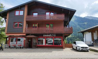 A modern building with two floors in the mountains. The ground floor houses the restaurant "sweetchill" with large windows. | © Kleinwalsertal Tourismus | N. Lughammer