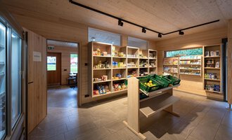 A small grocery store with shelves full of products. The walls are made of wood, and the light is bright and inviting. | © Campingplatz Vorderboden GmbH | Marion Schwendiger