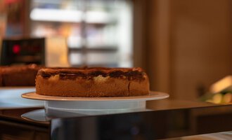 Ein köstlicher Kuchen auf einem Teller in einer Bäckerei. Der Kuchen hat eine goldene Kruste und eine appetitliche Füllung. | © Campingplatz Vorderboden GmbH | Marion Schwendiger