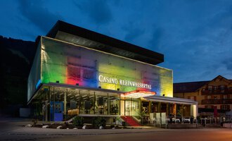 Ein modernes Casino mit bunten Lichtern in der Abenddämmerung. Es befindet sich im Kleinwalsertal und hat eine stilvolle Architektur. | © Casinos Austria | Arnd Ötting