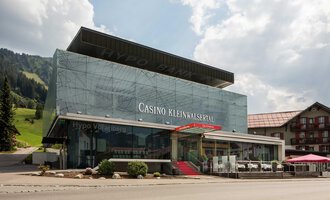 Ein modernes Casino mit Glasfassade in einer bergigen Umgebung. Vor dem Gebäude befinden sich Terrassen und Sitzbereiche. | © Casinos Austria | Arnd Ötting