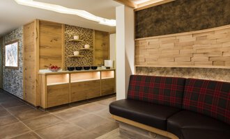 A modern reception area with wood paneling and comfortable seating. The atmosphere is warm and inviting. | © Hotel Leitner