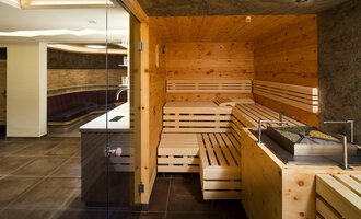 A modern sauna area made of wood with cozy loungers. The room is bright and invitingly designed. | © Hotel Leitner