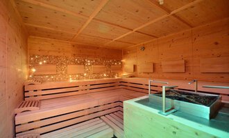 Eine gemütliche Sauna mit Holzbank und sanfter Beleuchtung. Der Raum strahlt Entspannung und Wärme aus. | © Hotel Alpenstüble KG | Manuel Riezler