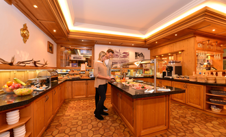 Ein stilvolles Buffet in einem gemütlichen Restaurant. Zwei Personen genießen die Auswahl an Speisen und Getränken. | © Hotel Alpenstüble KG