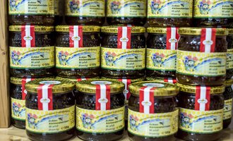 Eine Vielzahl von Gläsern mit Marmelade ist gestapelt. Die Gläser haben bunte Etiketten mit dekorativen Designs. | © Kleinwalsertal Tourismus | Dominik Berchtold