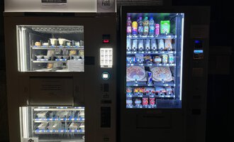 Two vending machines stand next to each other. The left machine offers frozen food, while the right one contains various drinks and snacks. | © Gerd am Herd | Gerd Hammerer