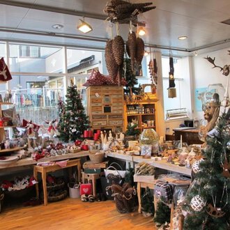 An inviting gift shop with festive decorations. Christmas trees and lovingly designed products can be seen everywhere. | © HUIMWEA Alpendekor