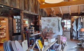 Ein gemütlicher Laden mit rustikalem Holzinterieur. Es gibt viele Produkte und Dekorationen, die zum Stöbern einladen. | © iKuh Schöne Ideen | Daniela Neumann