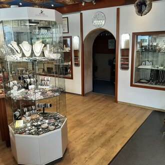 © Juwelier Demsky Walser Goldschmiede| Veronika Senn A jewelry store with a jewelry display in the center. Additional pieces of jewelry are displayed in showcases on the walls. | © Juwelier Demsky Walser Goldschmiede| Veronika Senn