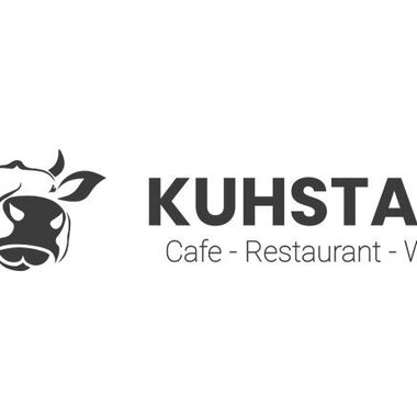 A simple logo featuring a cow head and the inscription "KUHSTALL". Subtitles are "Cafe - Restaurant - Wine".