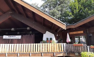 A cozy wooden building with a terrace and plants. The café invites you to relax. | © Kleinwalsertal Tourismus | Veronika Senn