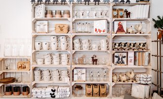 A decorative shelf with various dishes and household items. The display includes cups, glasses, and decorative elements in an appealing design. | © Herzstichle | Ninja Matt
