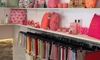 Ein bunt eingerichteter Laden mit Kissen und Wohnaccessoires in verschiedenen Rottönen. Die Regale sind ordentlich angeordnet und bieten eine freundliche Atmosphäre. | © Herzstichle | Ninja Matt