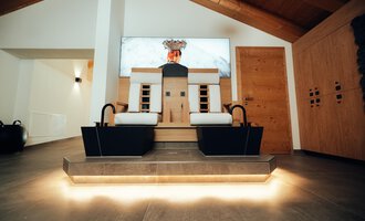 Ein moderner Wellnessbereich mit zwei Fußbad-Bereichen und einer stilvollen Holzverkleidung. Der Raum ist hell und einladend, ideal zum Entspannen.