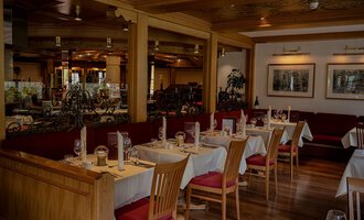 Ein gemütliches Restaurant mit Tischen und Stühlen aus Holz. Die Einrichtung ist warm und einladend, ideal für eine angenehme Mahlzeit. | © IFA Hotel Alpenhof Wildental | Andreas Froschauer