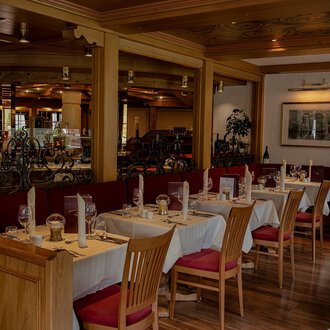 A cozy restaurant with wooden tables and chairs. The decor is warm and inviting, perfect for a pleasant meal. | © IFA Hotel Alpenhof Wildental