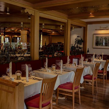 Ein gemütliches Restaurant mit Tischen und Stühlen aus Holz. Die Einrichtung ist warm und einladend, ideal für eine angenehme Mahlzeit. | © IFA Hotel Alpenhof Wildental