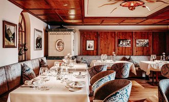 Ein elegantes Restaurant mit Holzvertäfelungen und stilvollen Tischen. Die gemütliche Atmosphäre wird durch die dekorativen Bilder und die geschmackvolle Einrichtung verstärkt. | © Hotel Birkenhöhe | Sascha Gast