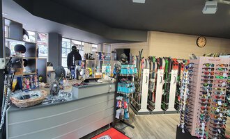 Ein Sportgeschäft mit Ski- und Snowboardausrüstung. Im Hintergrund sind Sonnenbrillen und andere Zubehörartikel angeboten. | © Ski + Sport Zunzer Mittelberg
