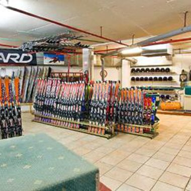 Ein Skiverleih mit vielen Skiern und Snowboards in einem gut organisierten Raum. Die Wände sind mit Ausrüstung und Zubehör zum Wintersport bedeckt. | © Aparthotel Kleinwalsertal Haller GmbH & Co KG