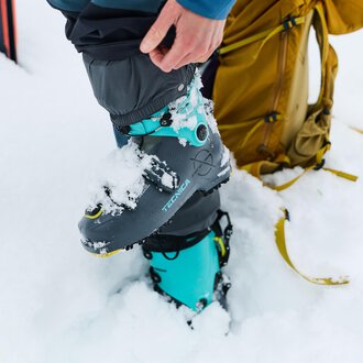 A man is repairing ski equipment and assembling a ski boot. In the background, numerous skis are standing. | © Kleinwalsertal Tourismus | Oliver Farys