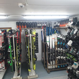 © IFA Hotel Alpenrose Ein Raum mit mehreren Skiern und Skischuhen, ordentlich gestapelt auf Regalen. Die Beleuchtung ist hell und es sieht nach einem Ski-Verleih aus. | © IFA Hotel Alpenrose