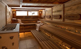 Eine moderne Sauna mit Holzbank und sanfter Beleuchtung. Das Raumdesign schafft eine entspannende Atmosphäre. | © Aparthotel Kleinwalsertal Haller GmbH & Co KG