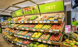 Ein buntes Obstregal in einem Supermarkt mit frischen Früchten wie Äpfeln, Bananen und Trauben. Die Regale sind gut gefüllt und ordentlich angeordnet. | © SPAR