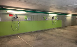 Eine moderne Tiefgarage mit Elektro-Ladepunkten. Die Wände sind grün gestrichen und die Beleuchtung ist hell. | © Naturhotel Chesa Valisa Hirschegg