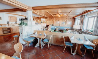 Ein einladendes Restaurant mit rustikalen Holzmöbeln und einer gemütlichen Atmosphäre. Der Raum ist hell und freundlich, ideal für gesellige Mahlzeiten.