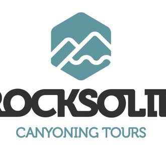 Ein Logo von "Rocksolid Canyoning Tours". Es zeigt stilisierte Berge und Wasserwellen in einer modernen Schriftart.