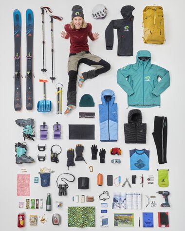 Ausrüstung für Wintersport, inklusive Skier, Skischuhe, Kleidung, Rucksack, Helm, und weitere Zubehörteile für eine Bergwanderung. | © Bergwelten Magazin