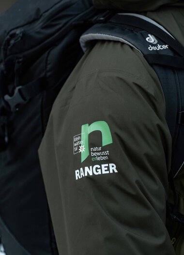 Nahaufnahme eines Rangers im dunklen grünen Jacke mit  | © Kleinwalsertal Tourismus eGen • Fotograf: Basti Heckl