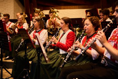 Musikerinnen der Trachtenkapelle Harmonie Mittelberg beim Sommerkonzert 2024 im Kleinwalsertal, während eines Auftritts mit Blasinstrumenten in traditioneller Tracht. | © Kleinwalsertal Tourismus eGen • Fotograf: Oliver Farys