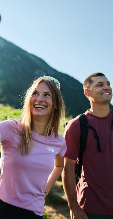 Drei junge Erwachsene beim Wandern in den Bergen, lachen und genießen die Natur im Kleinwalsertal. | ©  Kleinwalsertal Tourismus eGen • Fotograf: Oliver Farys