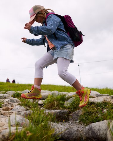 Kind eines Mädchens beim Wandern im Kleinwalsertal, springt über einen Steinweg im Sommer 2025. | © Kleinwalsertal Tourismus eGen • Fotograf: Oliver Farys