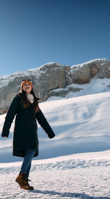 Zwei Personen beim Winterwandern in schneebedeigter Berglandschaft mit Felsen im Hintergrund, sonniger Himmel. | © Kleinwalsertal Tourismus eGen • Fotograf: Oliver Farys