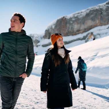 Zwei Menschen wandern im verschneiten Gebirge mit blauen Himmel und Mountain-Charakter im Hintergrund. | © Kleinwalsertal Tourismus eGen • Fotograf: Oliver Farys