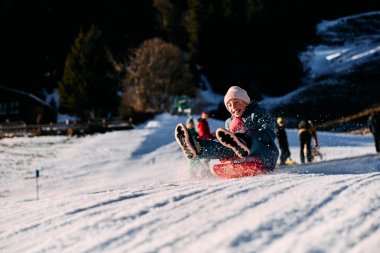 Ein Kind rodelnd im Schnee, Freude beim Winterspaß im Kleinwalsertal. | © Kleinwalsertal Tourismus eGen • Fotograf: Oliver Farys